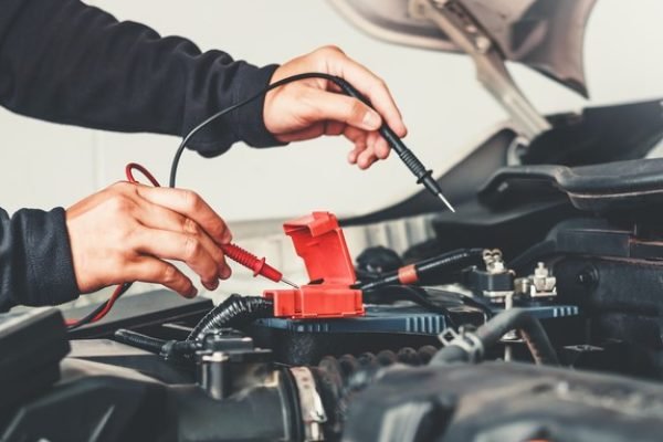 Automehaničar popravlja elektroinstalaciju vozila.