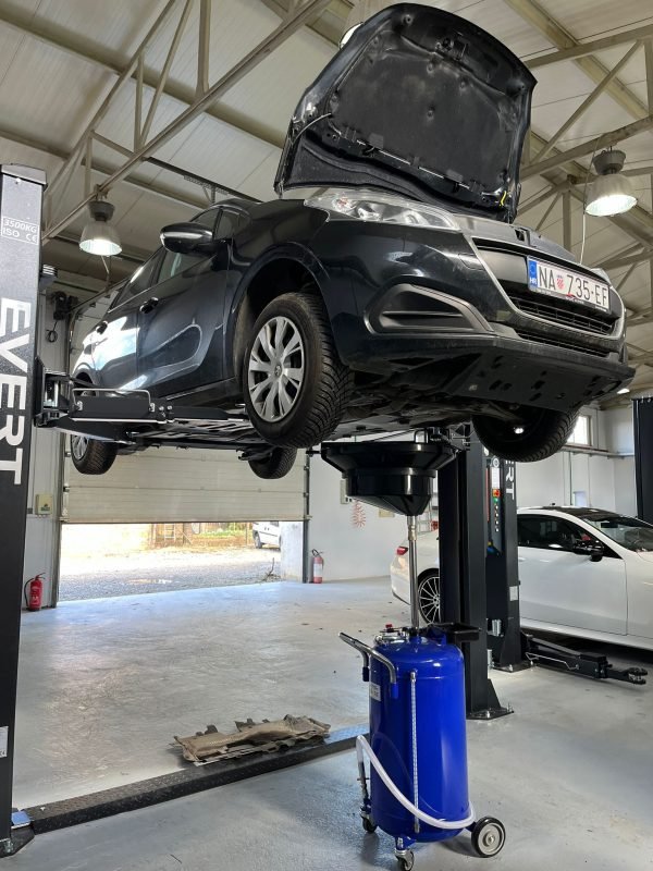 Automobil marke Peugeot na dizalici, mijenjanje motornog ulja i filtera.